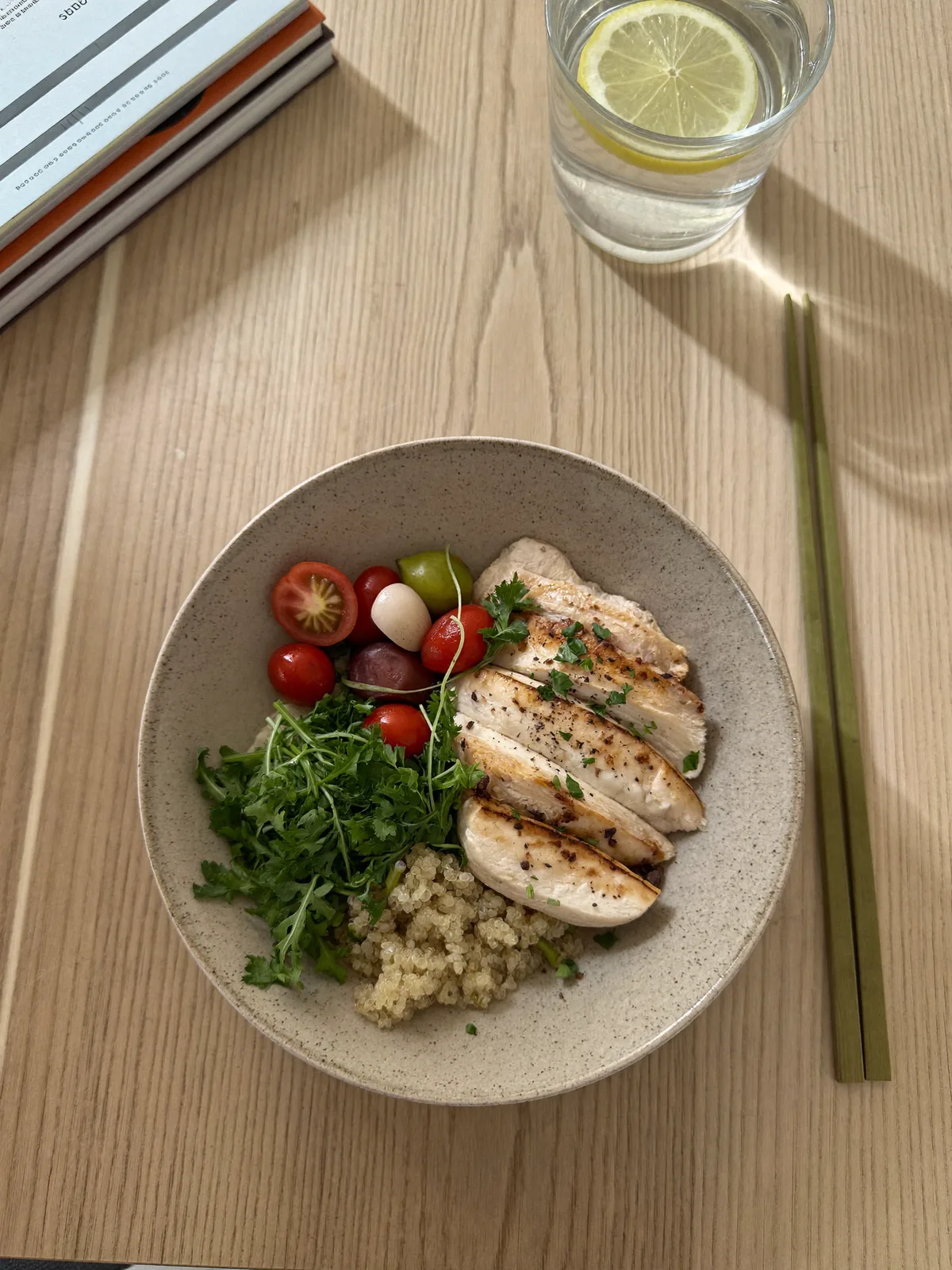 Ausgewogene Mahlzeit mit Hähnchen, Quinoa und Gemüse auf einem Bürotisch