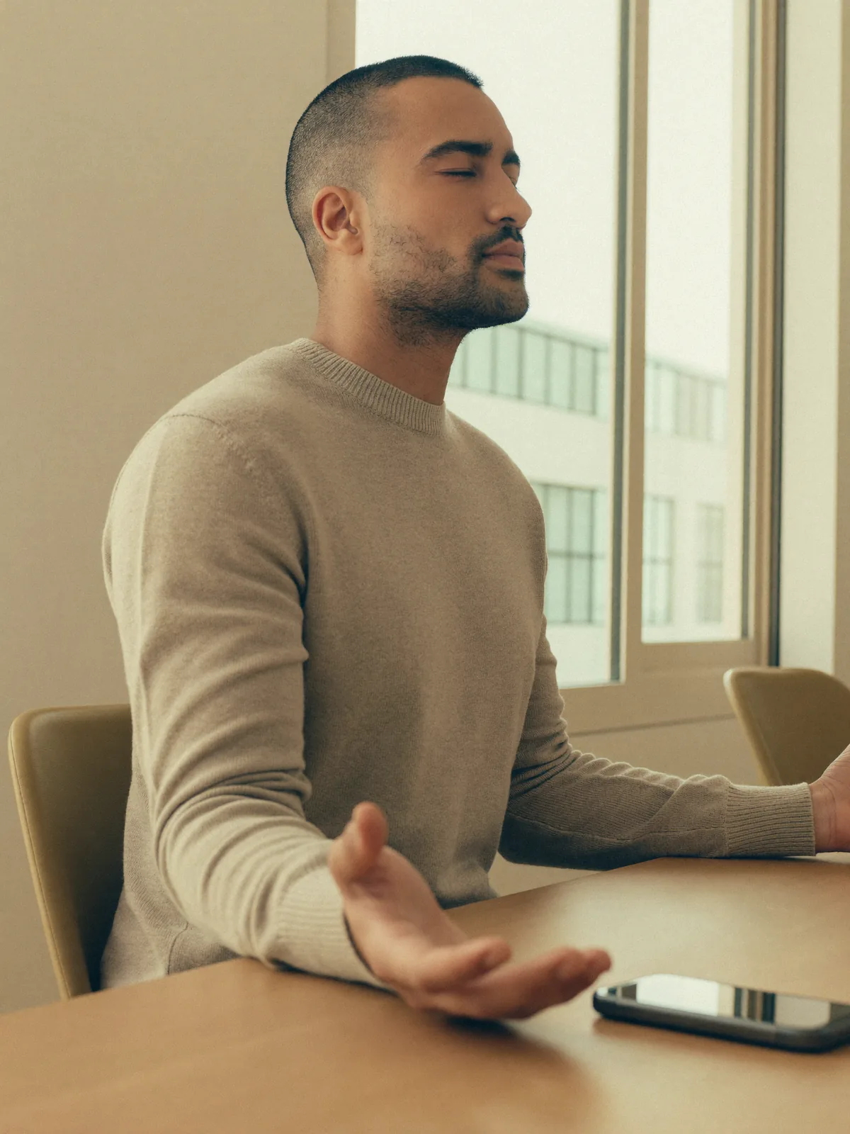 Mitarbeiter macht eine kurze Atemübung am Schreibtisch im Büro